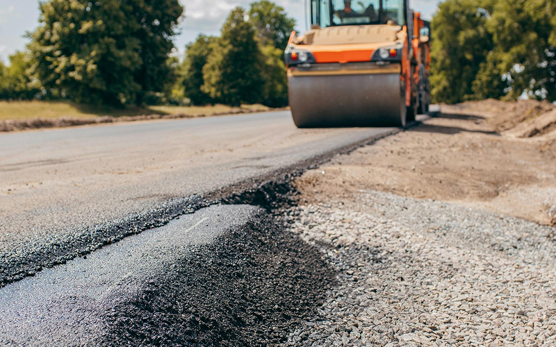 Heavy road roller compacting asphalt on a new road.