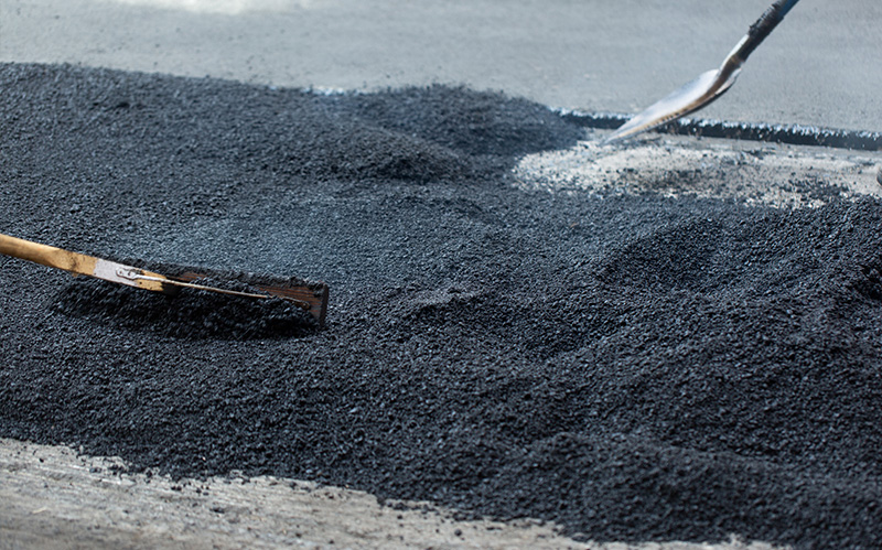 Close-up of a thick layer of loose asphalt binder